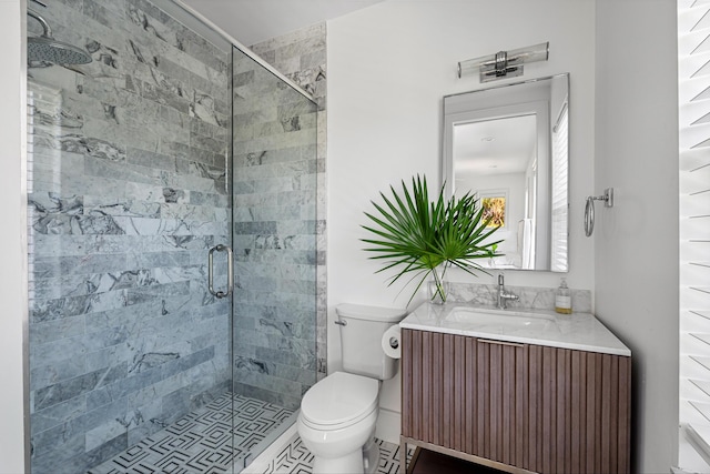 bathroom with a shower with door, vanity, and toilet