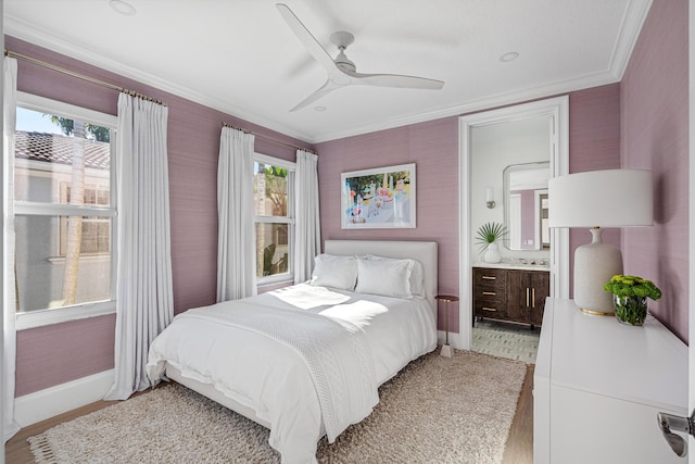 bedroom with crown molding, ceiling fan, light hardwood / wood-style floors, and ensuite bath