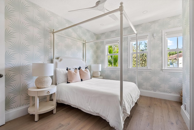 bedroom with ceiling fan and light hardwood / wood-style floors