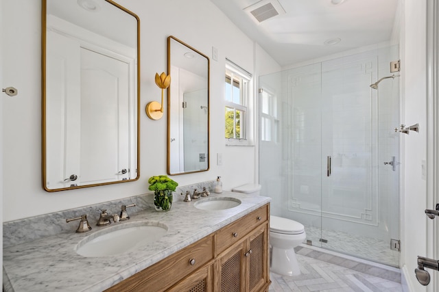 bathroom with a shower with door, vanity, and toilet