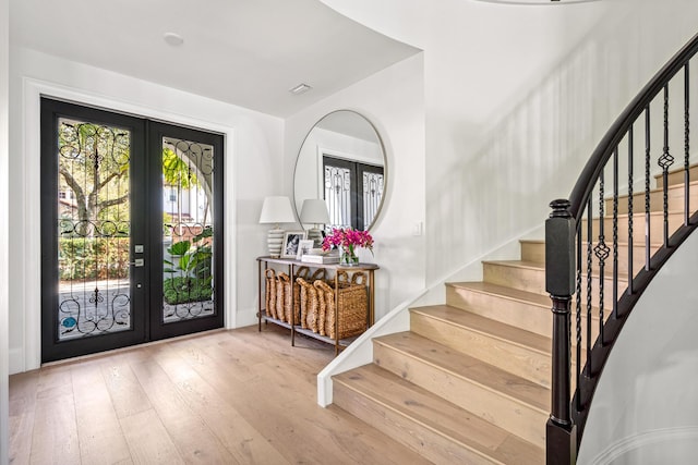 entryway with french doors and light hardwood / wood-style flooring