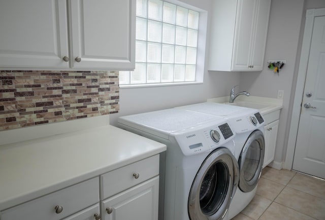 laundry area with cabinet space, light tile patterned flooring, a sink, and independent washer and dryer