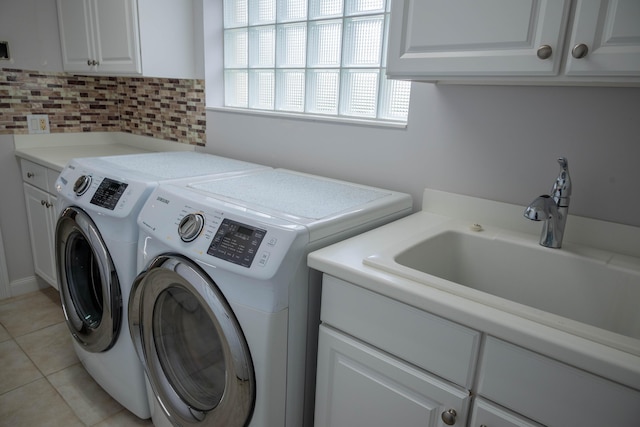 laundry area featuring washer and clothes dryer, light tile patterned flooring, a sink, and cabinet space