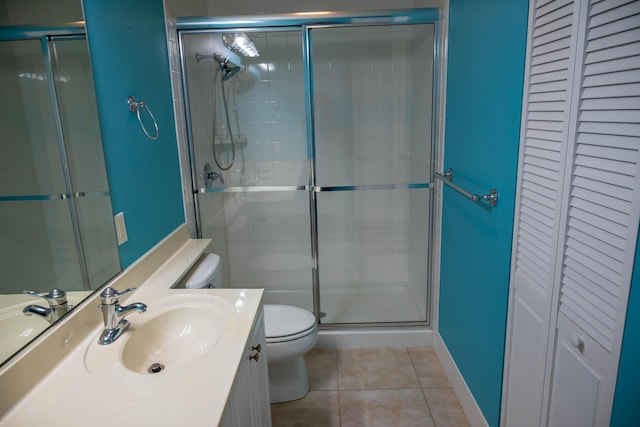 full bath with tile patterned flooring, toilet, vanity, a closet, and a stall shower