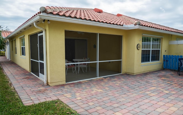 back of property with a patio area, a tiled roof, and stucco siding