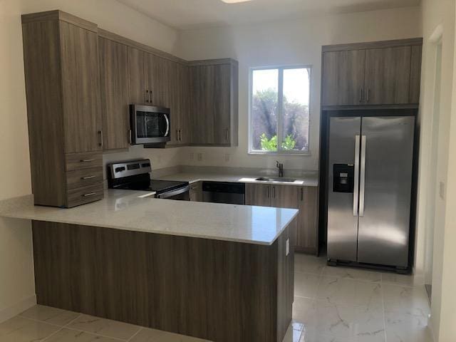 kitchen with kitchen peninsula, appliances with stainless steel finishes, and sink