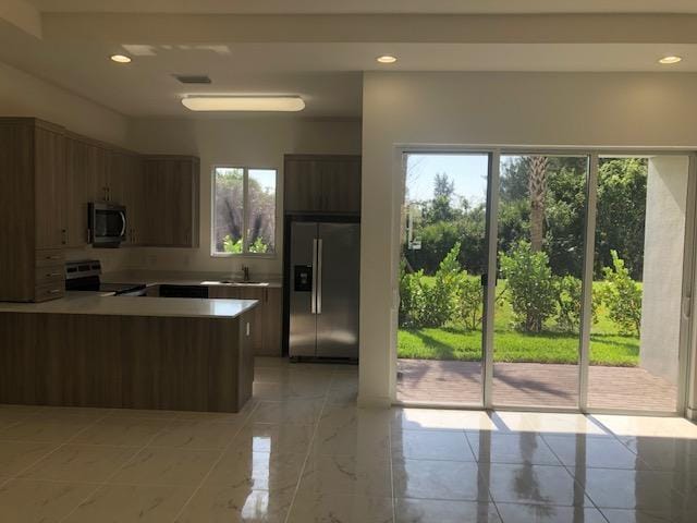 kitchen with kitchen peninsula, appliances with stainless steel finishes, and sink