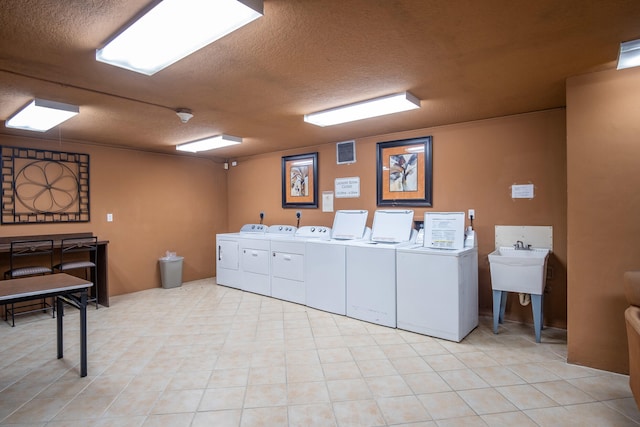 laundry area featuring washer and clothes dryer and a textured ceiling