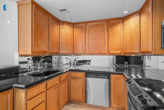 kitchen with sink, dark stone counters, and appliances with stainless steel finishes