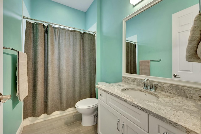 bathroom with toilet, vanity, and a shower with shower curtain