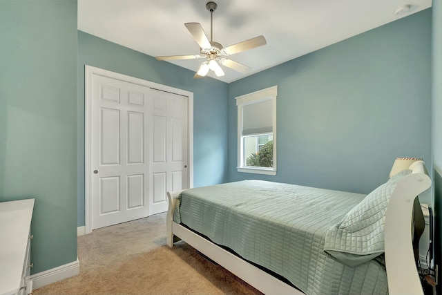 carpeted bedroom with ceiling fan and a closet