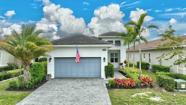 view of front facade with a garage and central AC unit