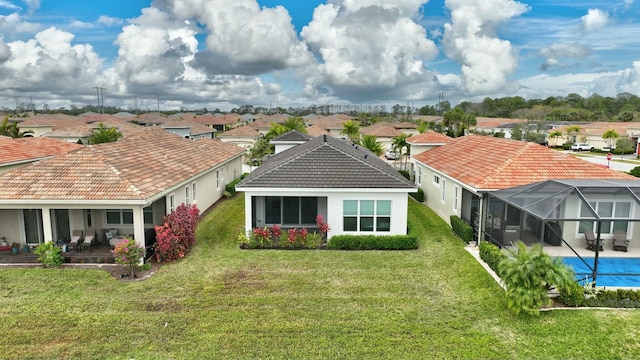 back of house featuring a lanai, a yard, and a patio