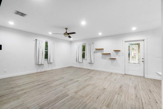 unfurnished living room featuring ceiling fan, a healthy amount of sunlight, and light hardwood / wood-style flooring