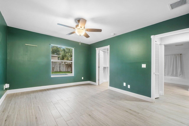 empty room with ceiling fan and light hardwood / wood-style floors