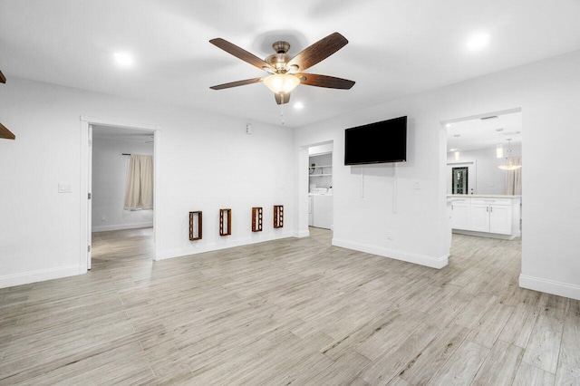 unfurnished living room featuring ceiling fan and light hardwood / wood-style flooring