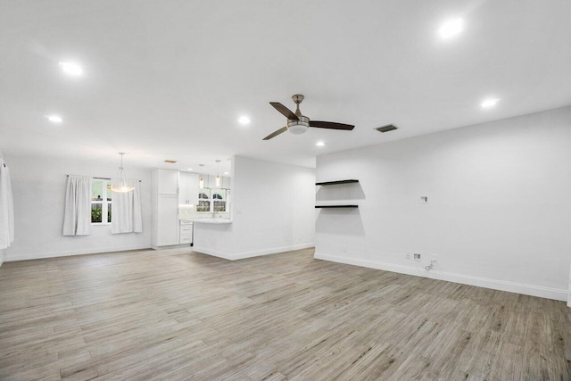 unfurnished living room with ceiling fan and light hardwood / wood-style flooring