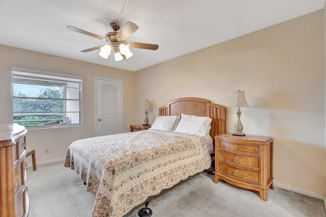 carpeted bedroom featuring a textured ceiling, ceiling fan, and a closet