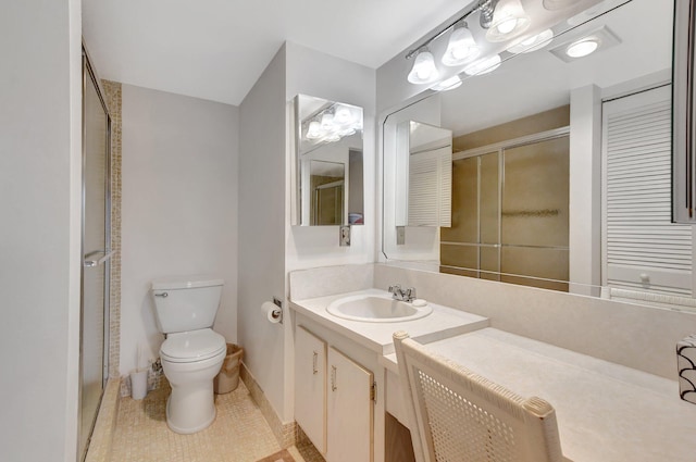 bathroom featuring a shower with shower door, toilet, vanity, and tile patterned flooring