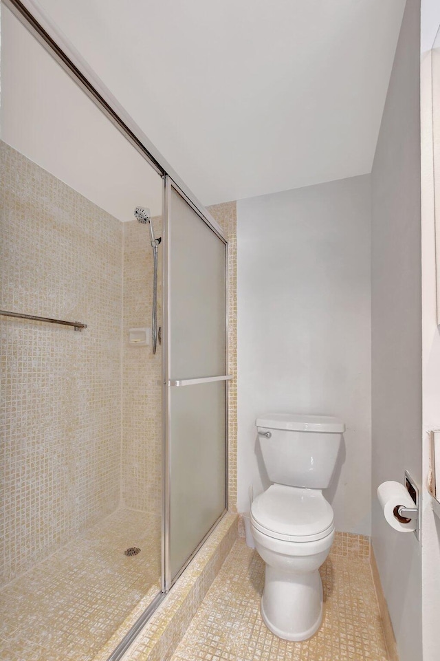 bathroom with toilet, tile patterned floors, and an enclosed shower