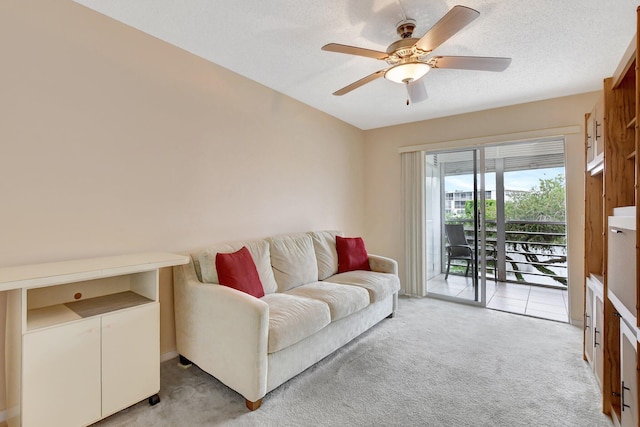 carpeted living room with ceiling fan and a textured ceiling