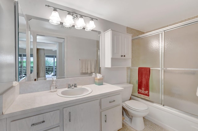 full bathroom featuring bath / shower combo with glass door, toilet, vanity, and tile patterned flooring