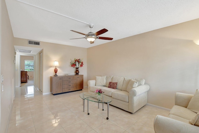 tiled living room with ceiling fan and a textured ceiling