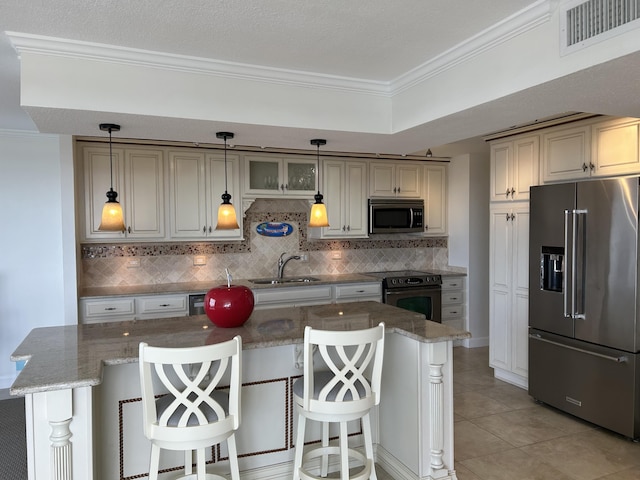 kitchen featuring backsplash, a kitchen island, a breakfast bar, sink, and stainless steel appliances