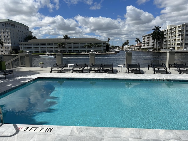 view of swimming pool with a water view and a patio area