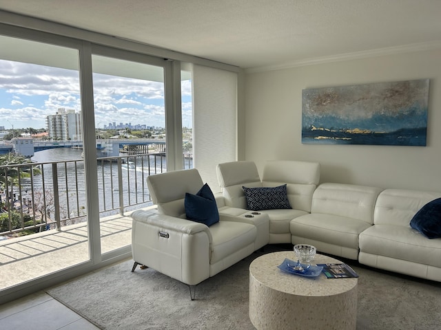 living room featuring tile patterned floors, a wall of windows, a water view, and ornamental molding