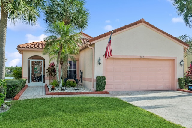 mediterranean / spanish house featuring a garage and a front yard