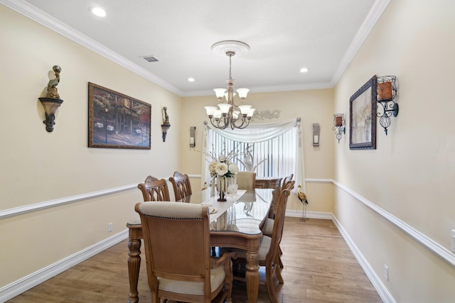 dining area featuring hardwood / wood-style flooring, ornamental molding, and a notable chandelier