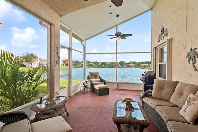 sunroom / solarium featuring ceiling fan, a water view, and vaulted ceiling