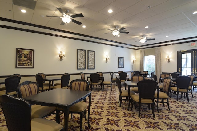 dining area featuring ceiling fan, light colored carpet, and crown molding