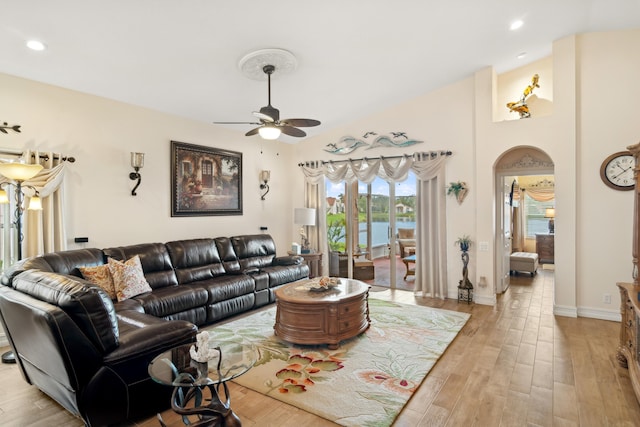 living room featuring ceiling fan, lofted ceiling, and light hardwood / wood-style floors