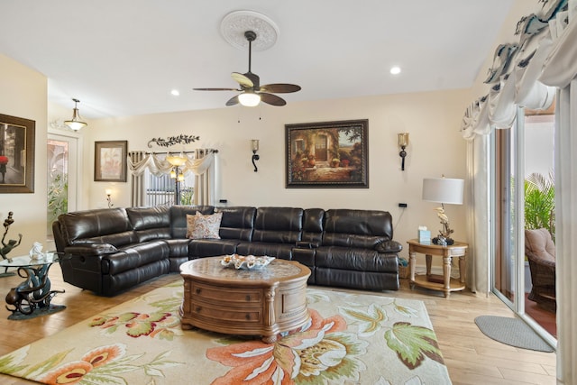 living room featuring ceiling fan and light hardwood / wood-style flooring