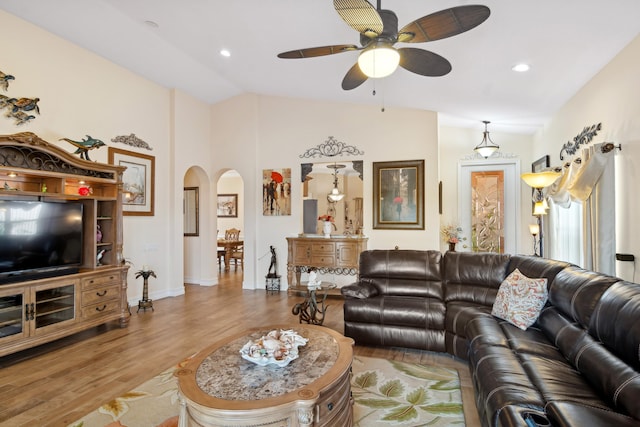 living room featuring light hardwood / wood-style floors, ceiling fan, and vaulted ceiling