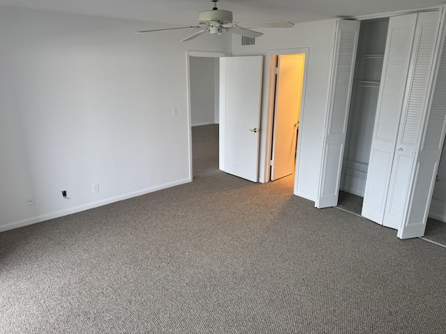 unfurnished bedroom with ceiling fan, dark carpet, and a closet