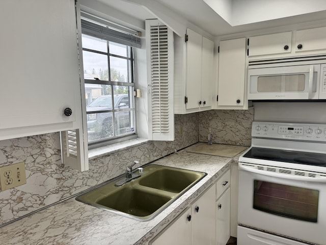 kitchen featuring decorative backsplash, sink, white appliances, and white cabinetry