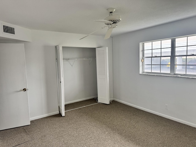 unfurnished bedroom with ceiling fan, carpet flooring, and a closet