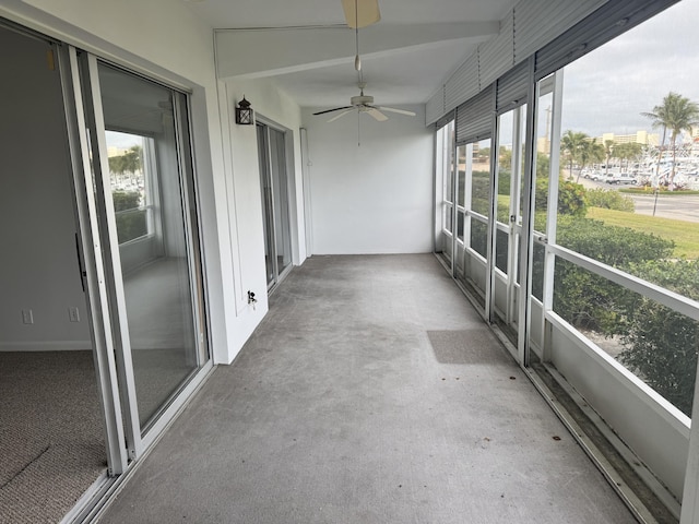 unfurnished sunroom with ceiling fan