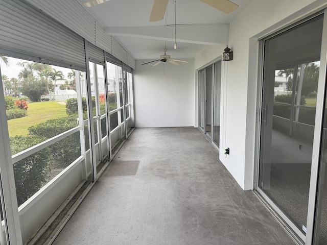 unfurnished sunroom with ceiling fan and vaulted ceiling