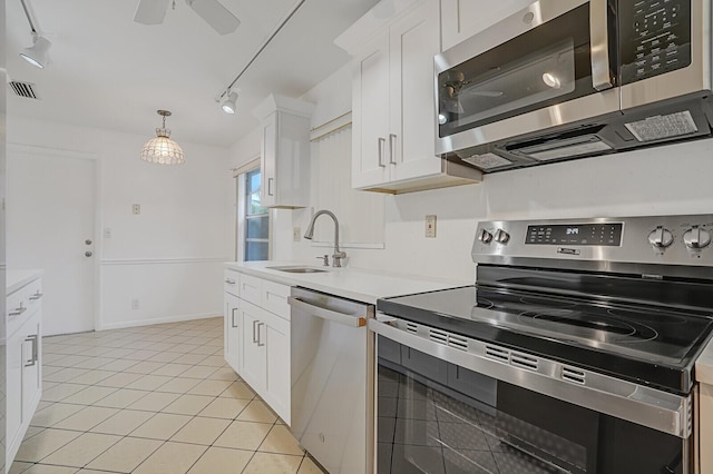 kitchen featuring white cabinets, appliances with stainless steel finishes, sink, ceiling fan, and light tile patterned floors