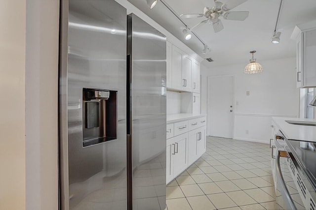 kitchen with electric range, light tile patterned flooring, track lighting, white cabinets, and stainless steel fridge