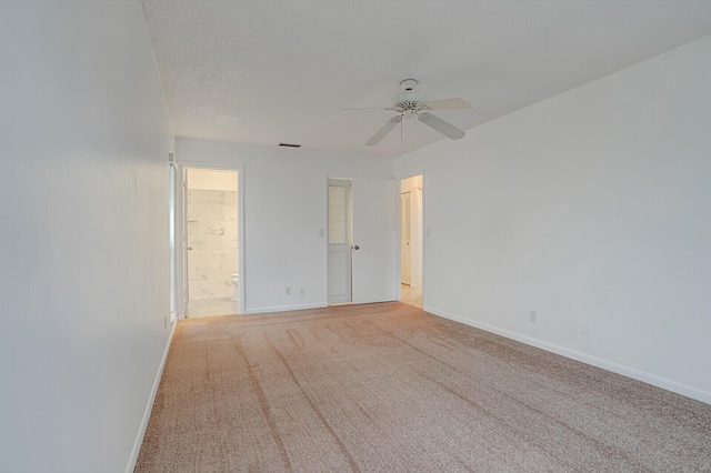 carpeted spare room featuring a textured ceiling and ceiling fan