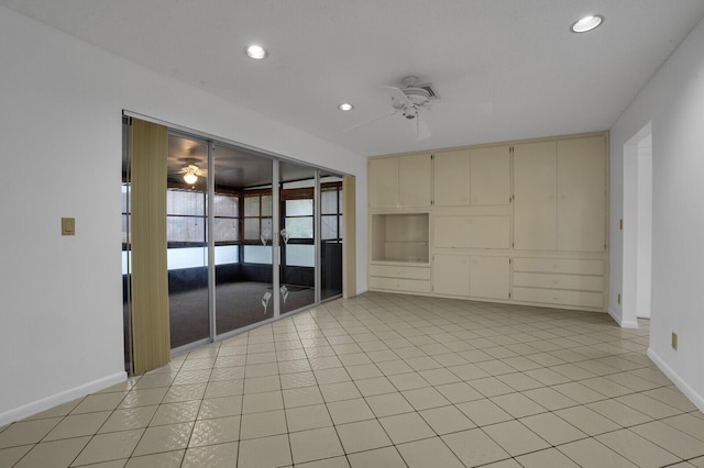 tiled spare room featuring ceiling fan