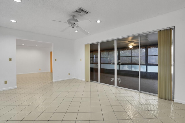 tiled spare room featuring a textured ceiling and ceiling fan