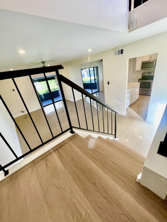 stairs featuring tile patterned flooring and a textured ceiling