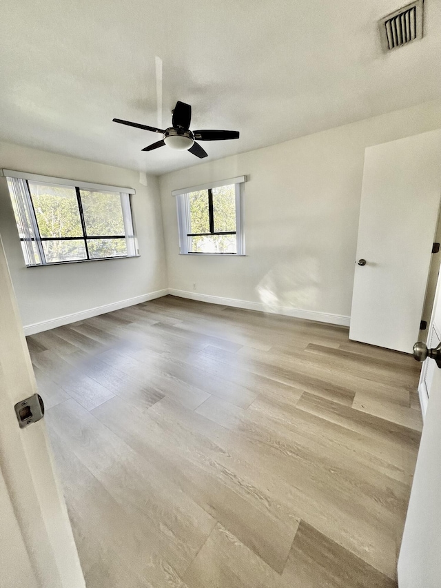 unfurnished room with ceiling fan and light wood-type flooring