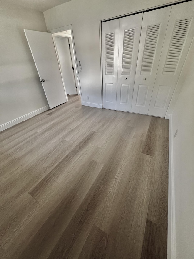 unfurnished bedroom featuring a closet and light hardwood / wood-style flooring